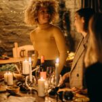 Warm and inviting dinner party scene with candles illuminating smiling guests.